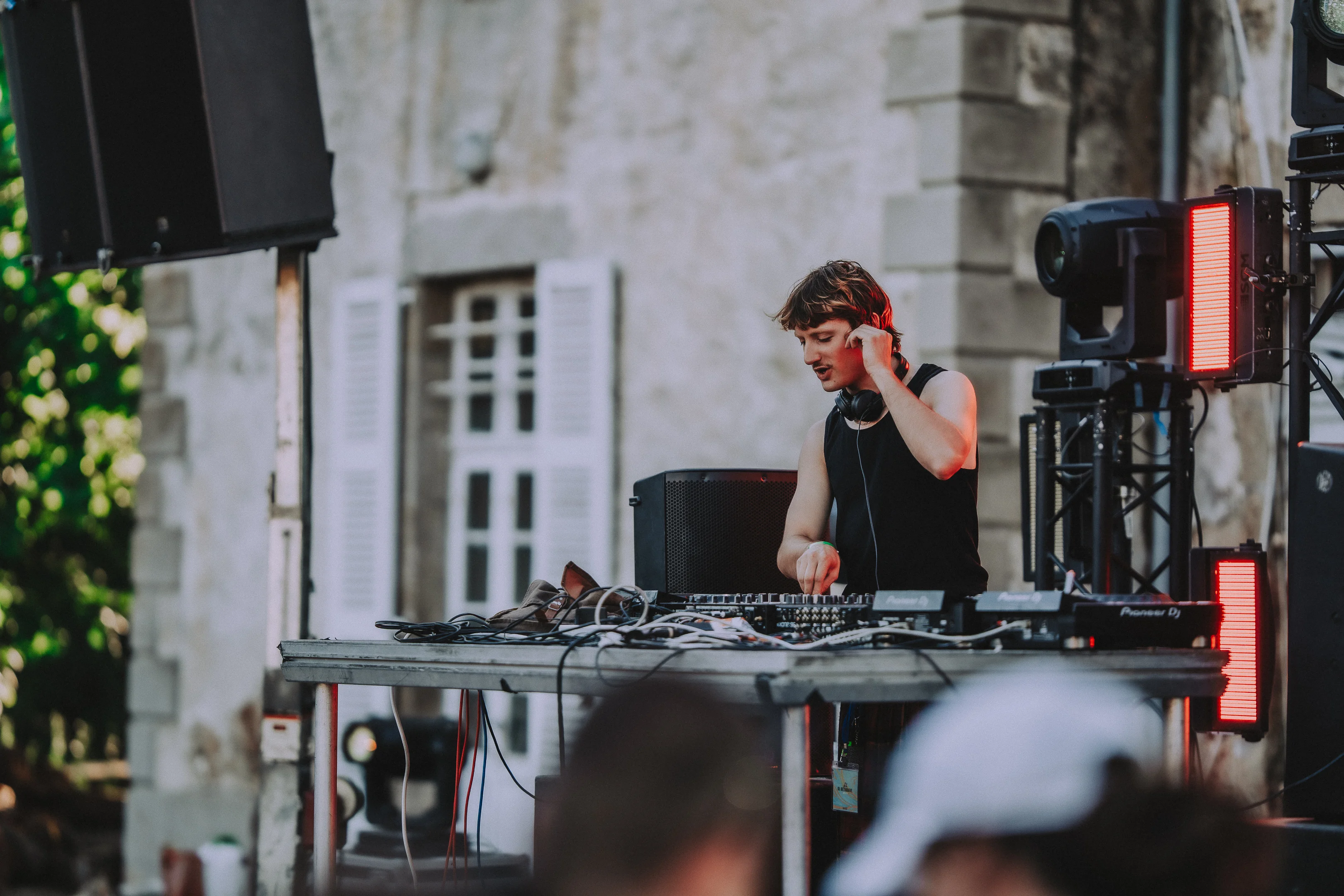 DJ sur scène ajustant son casque pendant un set au M2A Festival