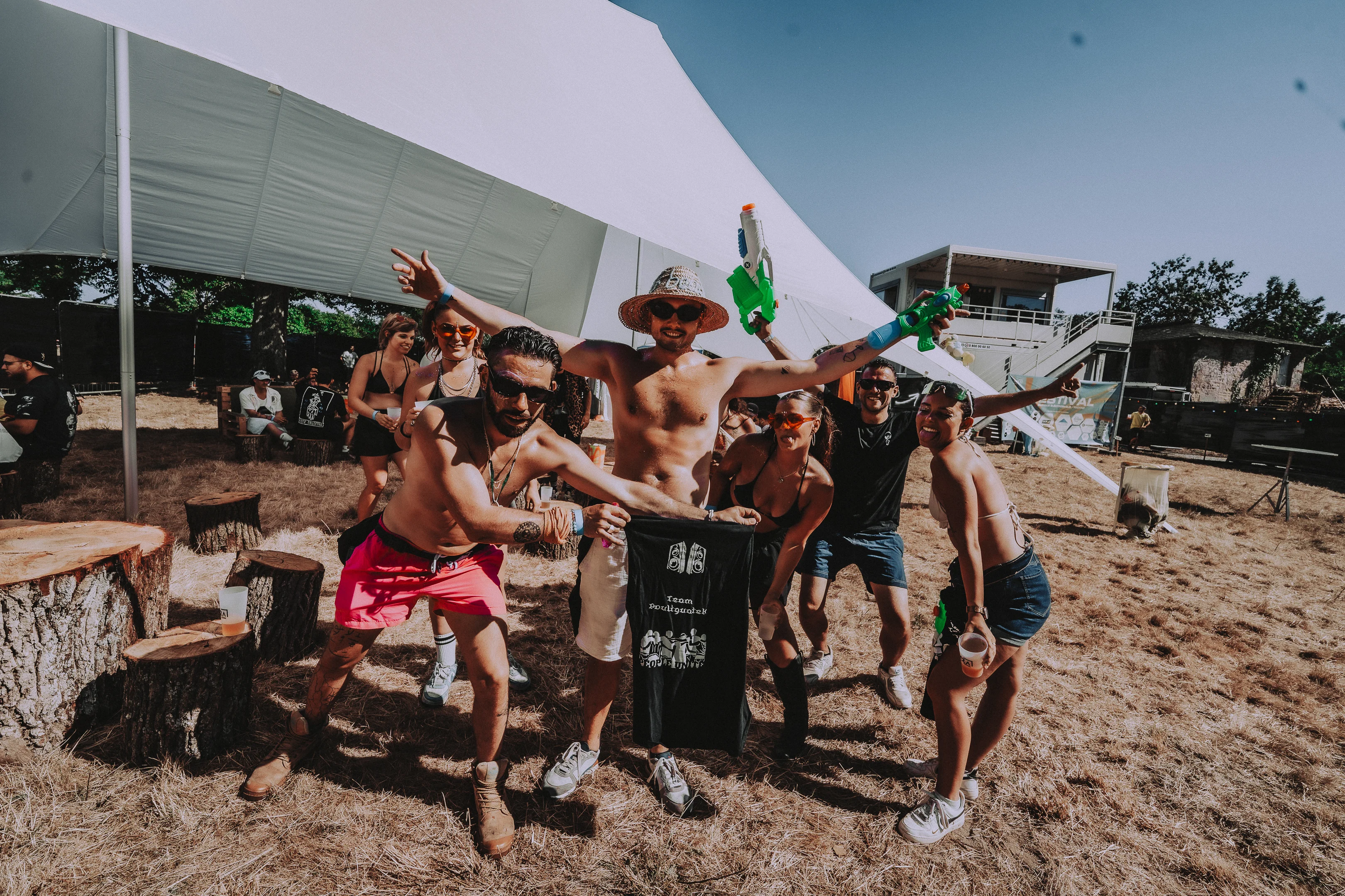 Groupe de festivaliers célébrant au M2A Festival en plein air sous le soleil.