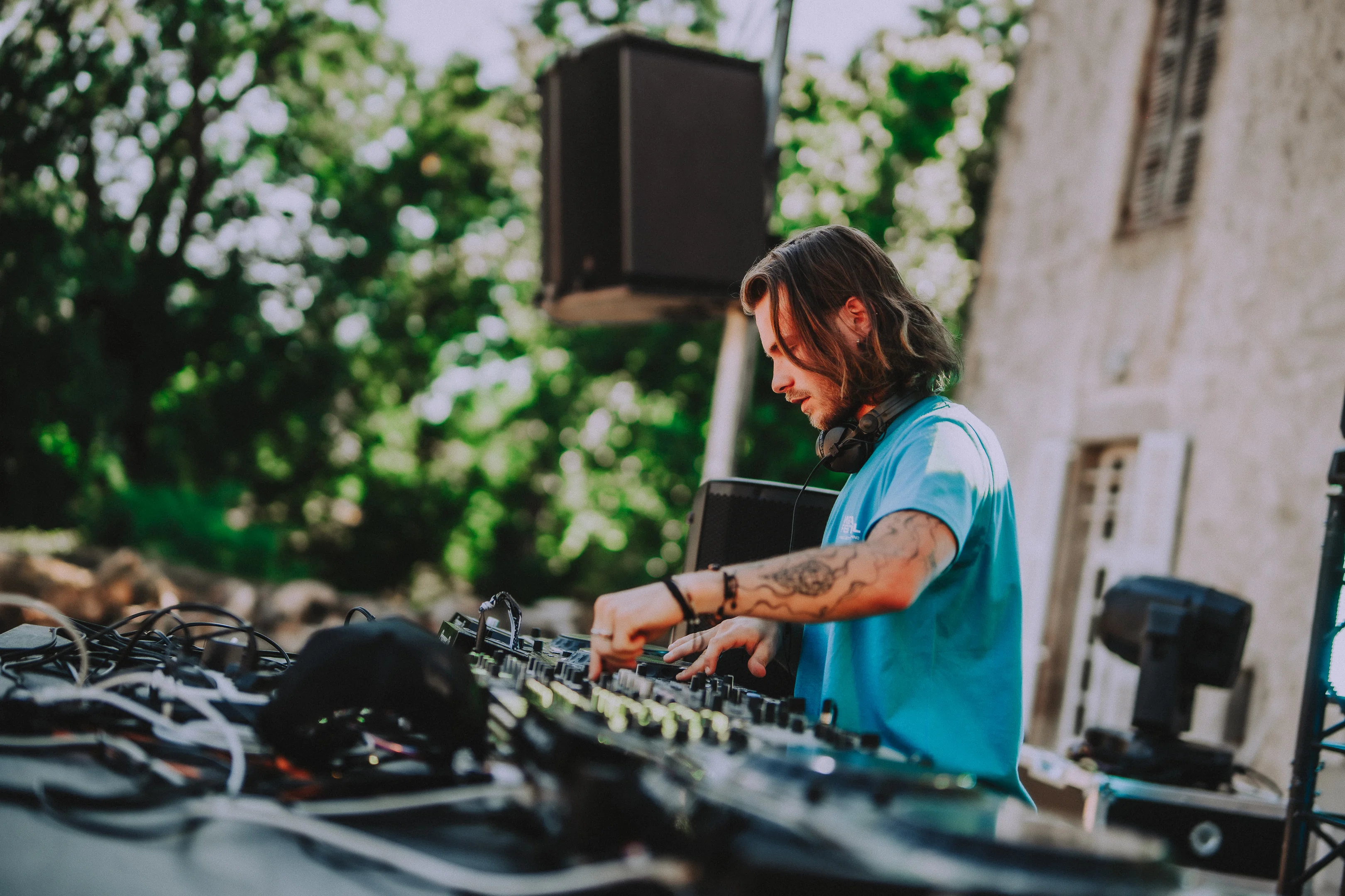 DJ en train de mixer sur la scène extérieure ensoleilée du M2A Festival