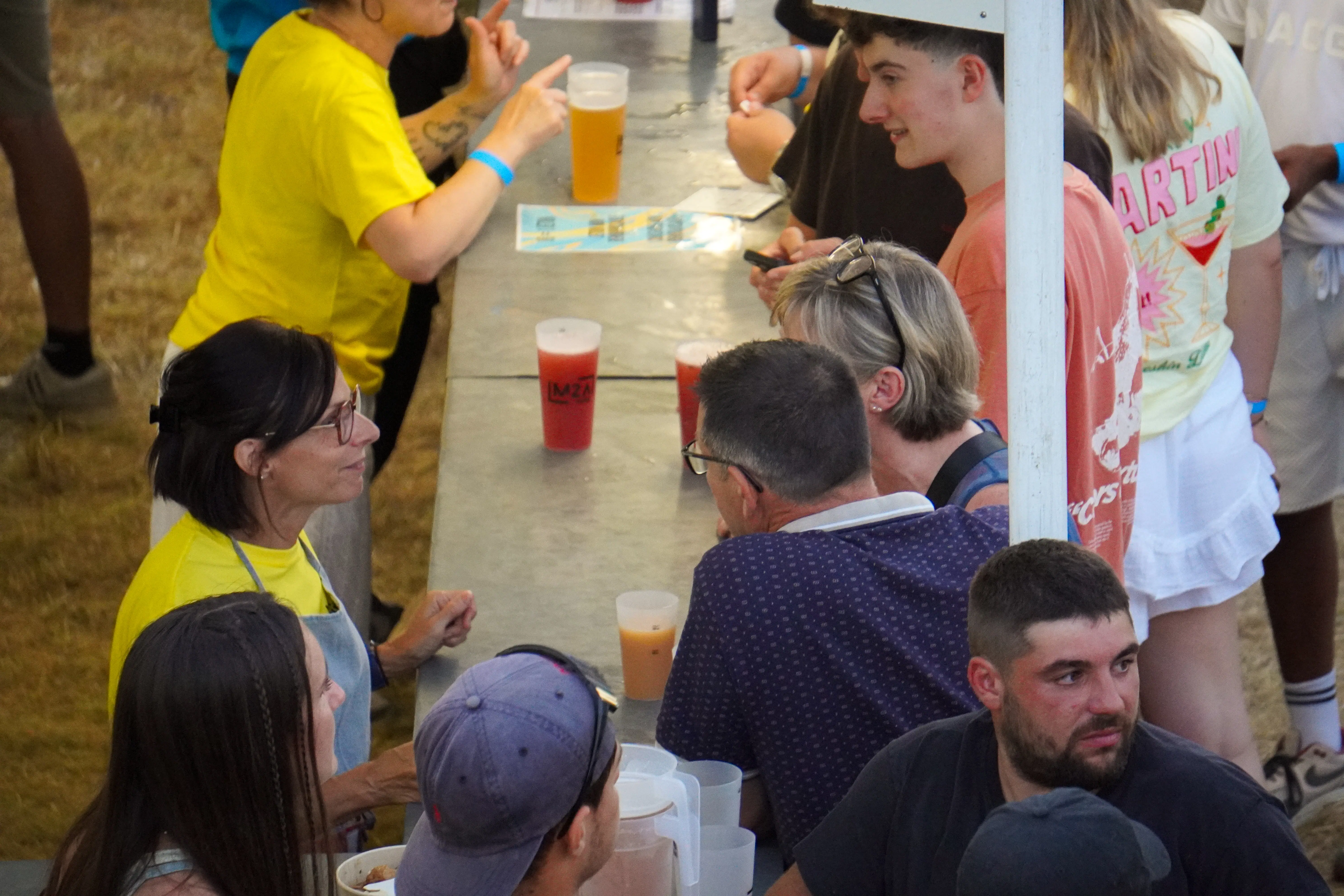 Bénévoles servant des boissons au bar du M2A Festival avec des gobelets réutilisables