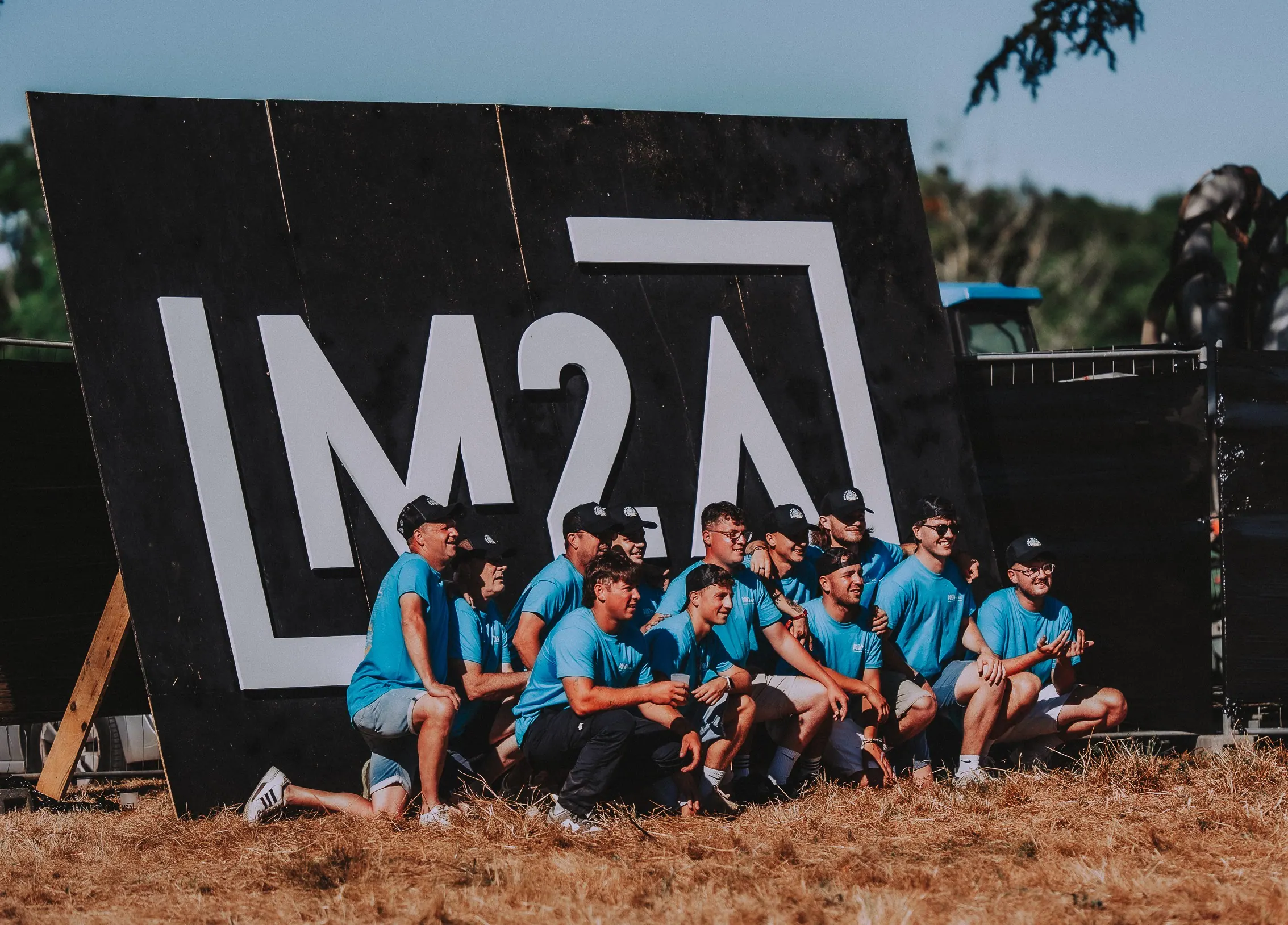 L'équipe organisatrice du M2A Festival devant le panneau M2A Festival lors de l'édition 2025.